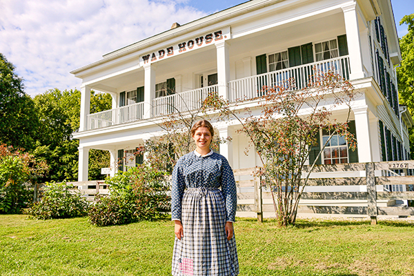 Woman standing in front of Wade House in a dress