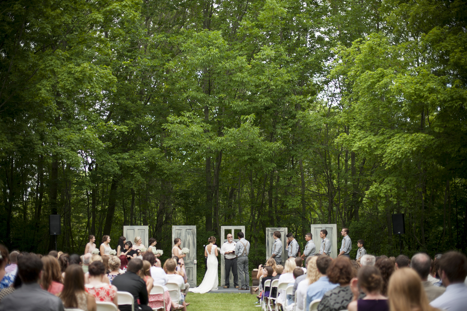 The Meadow is a wedding venue situated near a large copse of trees that surround a small lawn. At this weeding ceremony the bride and groom used old distressed doors as a back drop to their alter. 