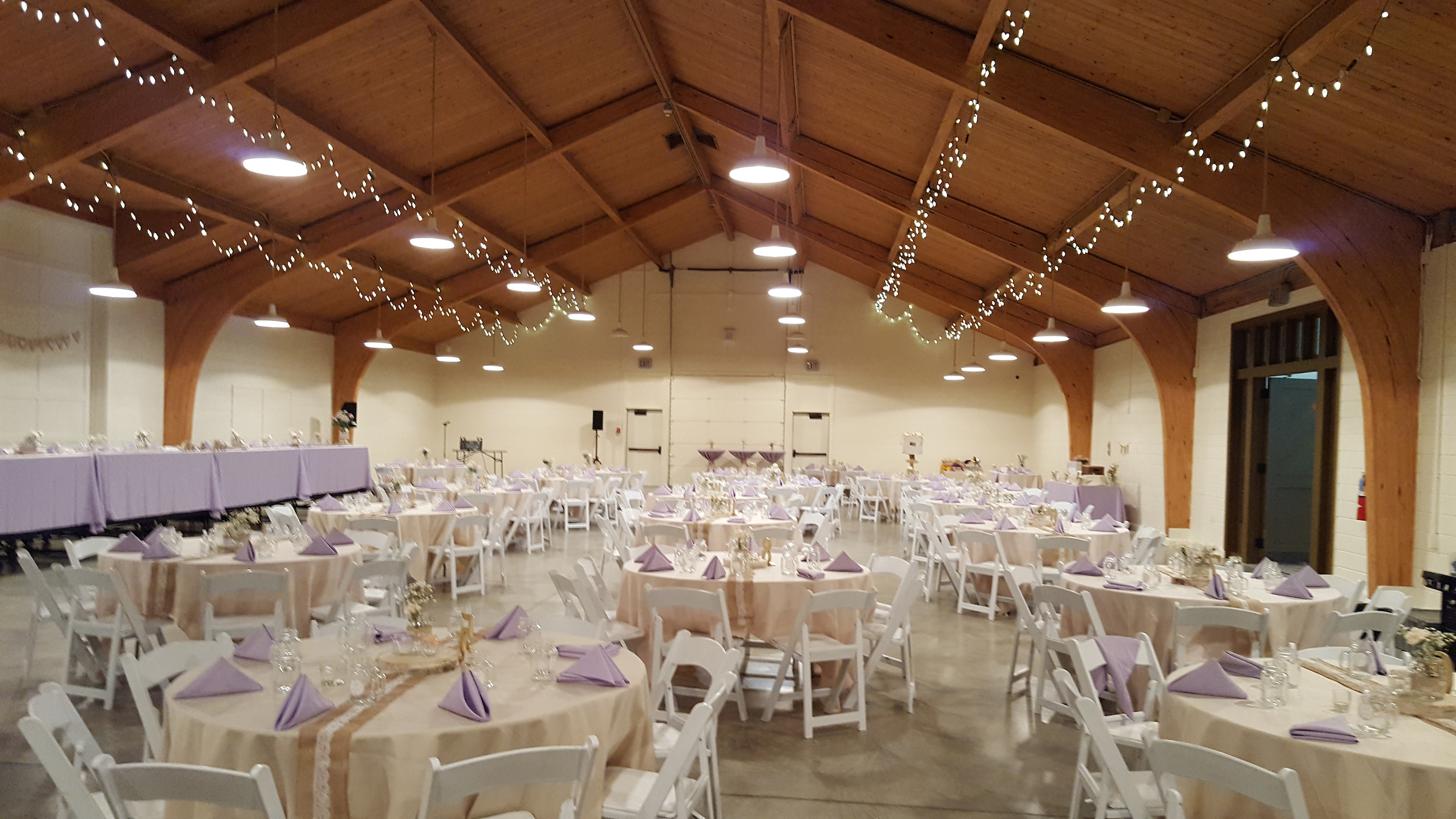 The pavilion set up in white and lilac for this indoor wedding reception. 