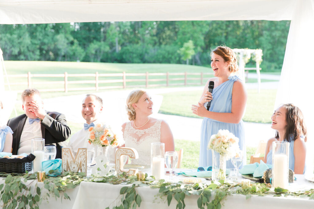 The maid of honor gives a speech at a wedding reception on the lawn