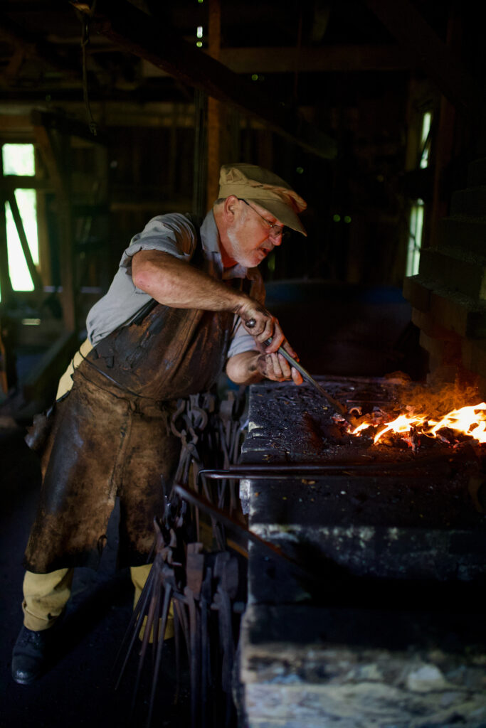 A man works in a blacksmith forge